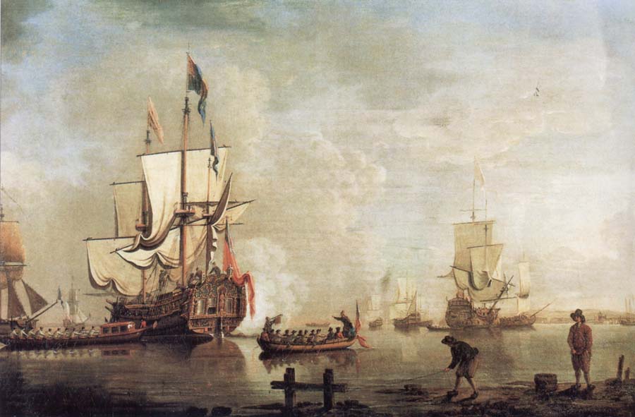 The Royal Caroline in a calm estuary flying a Royal standard and surrounded by an attendant barge and other small boats